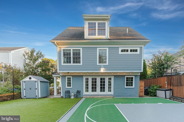 rear view of property with a fenced backyard, a yard, french doors, a storage shed, and an outbuilding