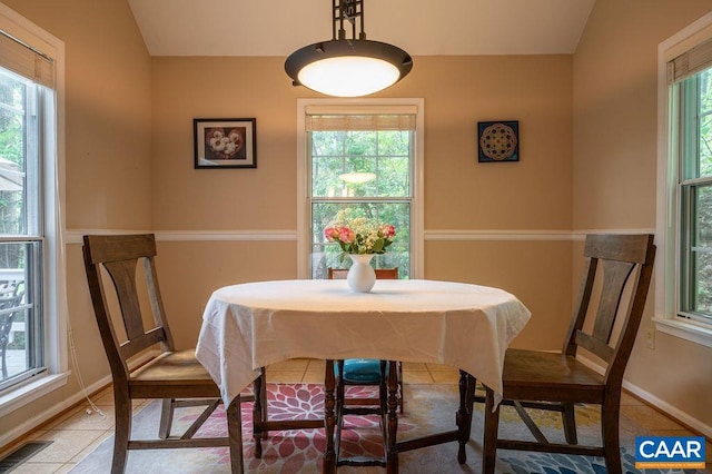 dining space featuring baseboards, tile patterned flooring, lofted ceiling, and visible vents
