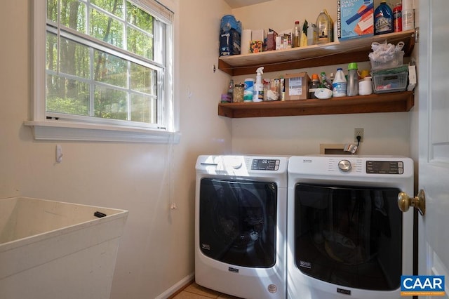 clothes washing area featuring laundry area, baseboards, and washer and dryer