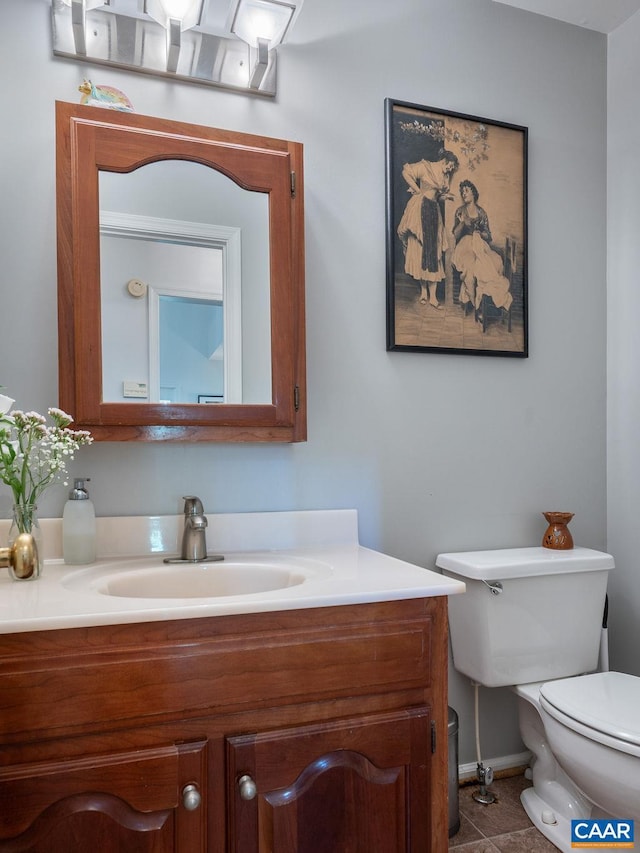 bathroom with vanity, tile patterned floors, baseboards, and toilet