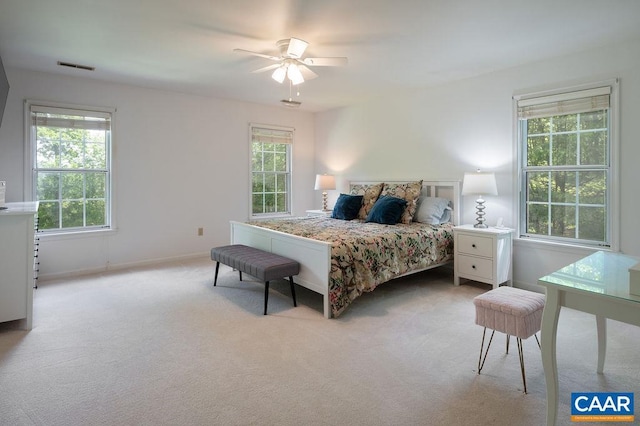 bedroom with baseboards, visible vents, light carpet, and ceiling fan