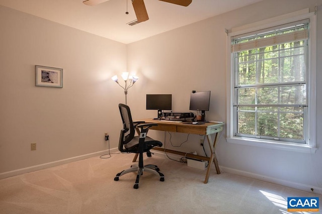 carpeted office space featuring a ceiling fan, baseboards, and a wealth of natural light
