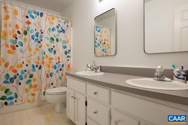full bath with a sink, tile patterned floors, toilet, and double vanity