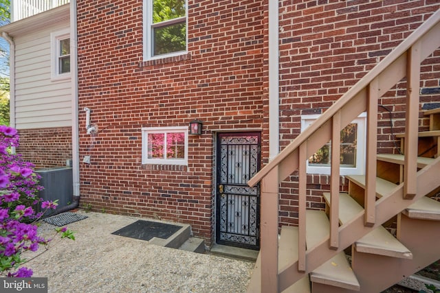 property entrance featuring brick siding and cooling unit