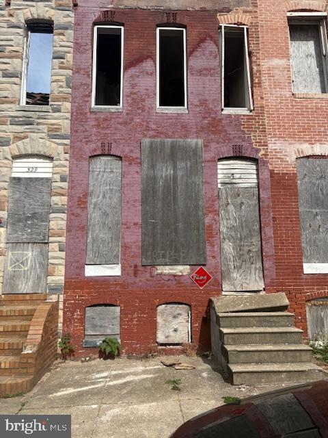 view of front of property featuring brick siding, stone siding, and entry steps