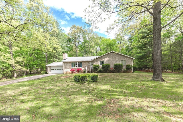 ranch-style home with driveway, a chimney, a front yard, brick siding, and an attached garage