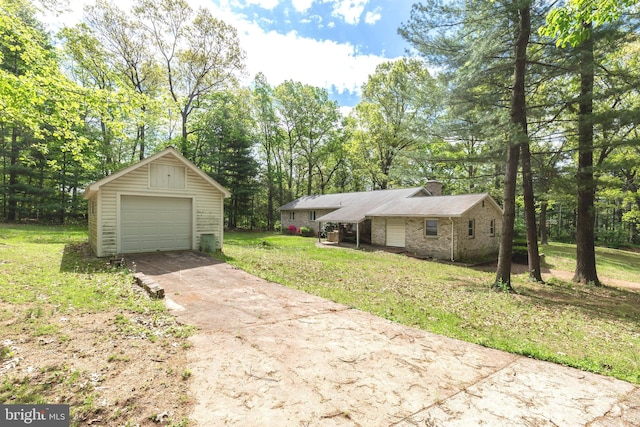view of front facade featuring a garage, a front yard, a chimney, an outdoor structure, and driveway