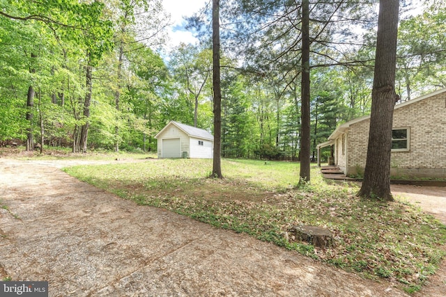 view of yard with a detached garage and an outdoor structure