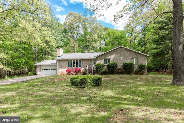 single story home with aphalt driveway, a chimney, brick siding, a front lawn, and an attached garage