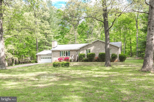 view of front facade with an attached garage, aphalt driveway, brick siding, a front yard, and a chimney