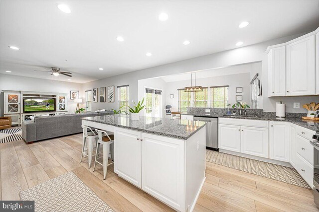 kitchen with a kitchen island, light wood-type flooring, recessed lighting, a sink, and dishwasher