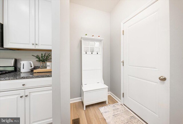 mudroom featuring baseboards, light wood finished floors, and visible vents