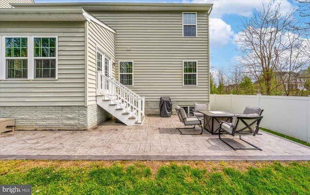 rear view of property with fence and a patio area