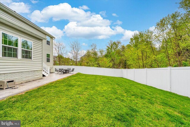 view of yard with a fenced backyard, entry steps, and a patio area