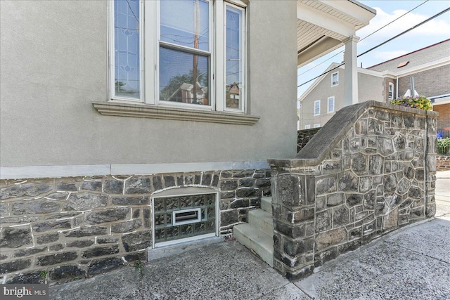 details featuring stucco siding and stone siding