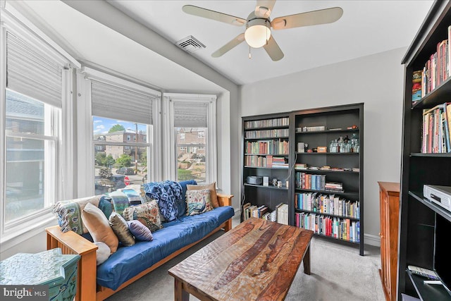 interior space featuring plenty of natural light, a ceiling fan, carpet flooring, and visible vents