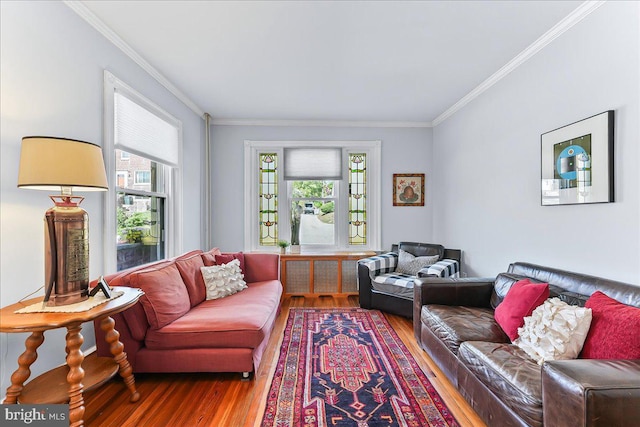 living area with plenty of natural light, ornamental molding, and wood finished floors