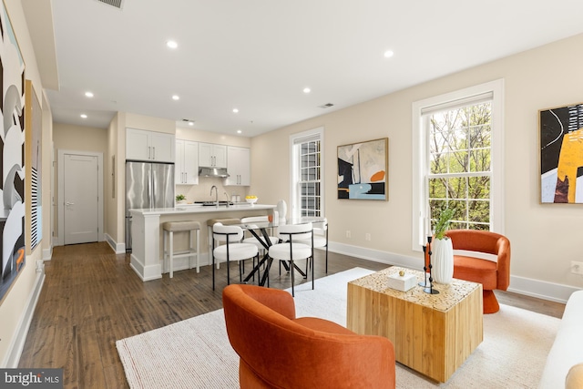 living room featuring recessed lighting, baseboards, and wood finished floors