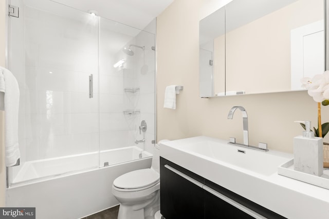 full bathroom featuring vanity, bath / shower combo with glass door, and toilet