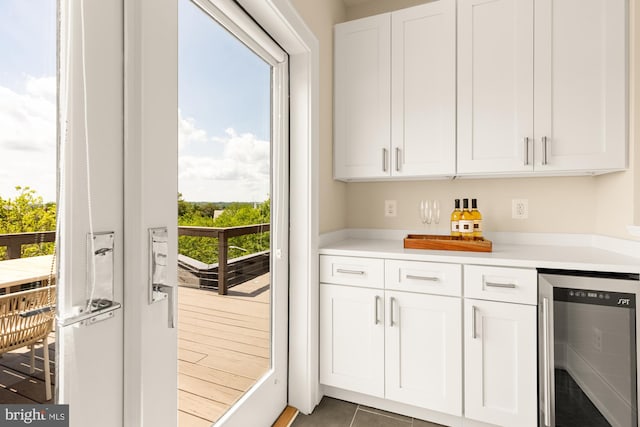 bar with a bar, wine cooler, and tile patterned floors