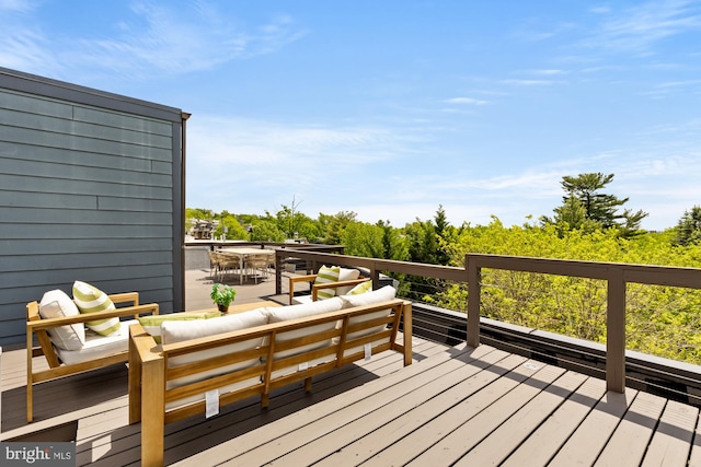 wooden terrace with an outdoor living space and outdoor dining area