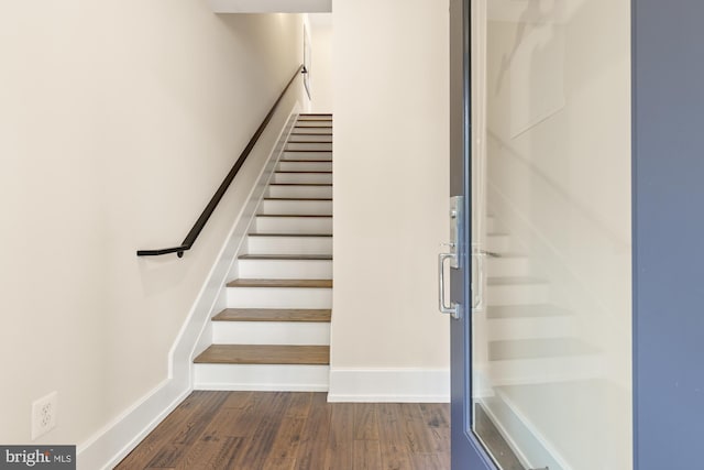 staircase with baseboards and wood finished floors