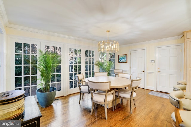 dining space featuring an inviting chandelier, light wood-style floors, and crown molding