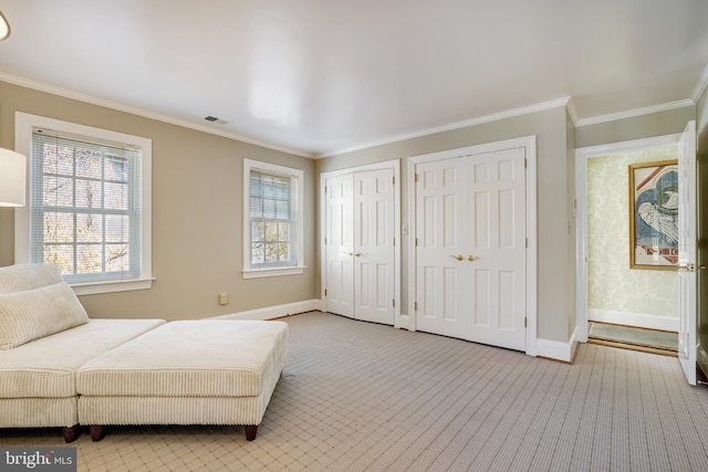sitting room with a healthy amount of sunlight, baseboards, ornamental molding, and visible vents
