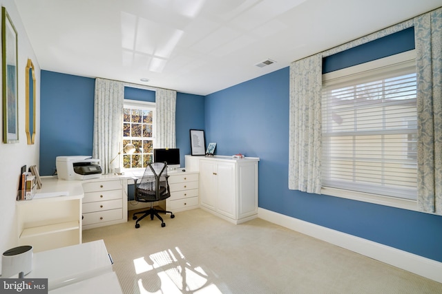 office with baseboards, visible vents, and light carpet