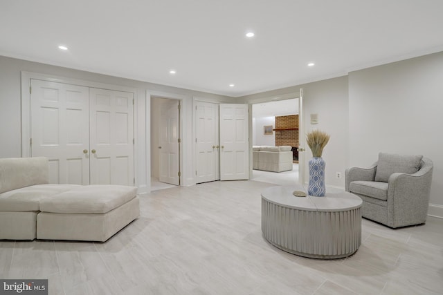 sitting room with recessed lighting, baseboards, and crown molding
