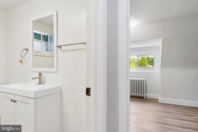 216 Homewood Ter, Baltimore, MD 21218 - bathroom with radiator heating unit, wood finished floors, vanity, and baseboards