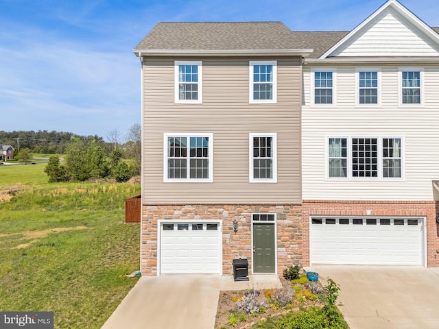 multi unit property featuring a garage, a front yard, driveway, and stone siding