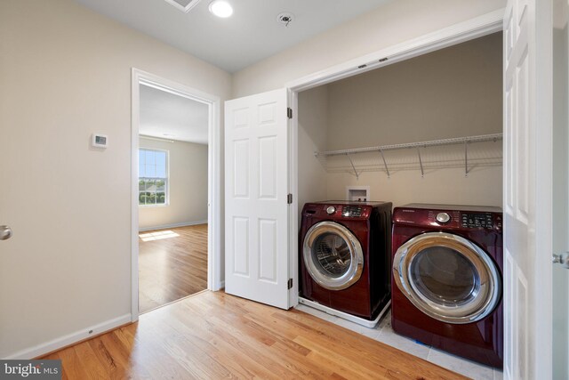 laundry room with washer and dryer, laundry area, baseboards, and light wood finished floors