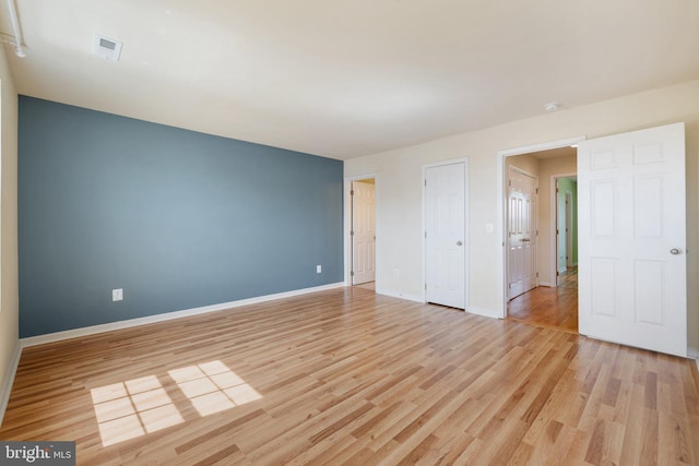 unfurnished bedroom with light wood-style floors, baseboards, and visible vents