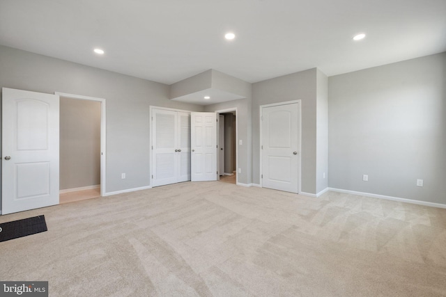 unfurnished bedroom featuring baseboards, recessed lighting, and light carpet
