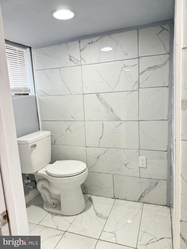 2526 W Franklin St, Baltimore, MD 21223 - bathroom featuring tile walls, toilet, and marble finish floor