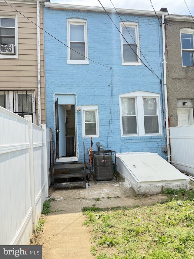 2526 W Franklin St, Baltimore, MD 21223 - back of property featuring brick siding, a fenced backyard, and cooling unit