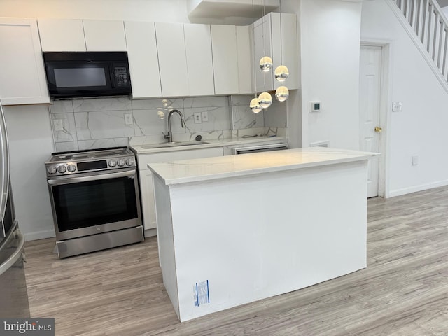 2526 W Franklin St, Baltimore, MD 21223 - kitchen with black microwave, a sink, light wood-style floors, electric stove, and backsplash