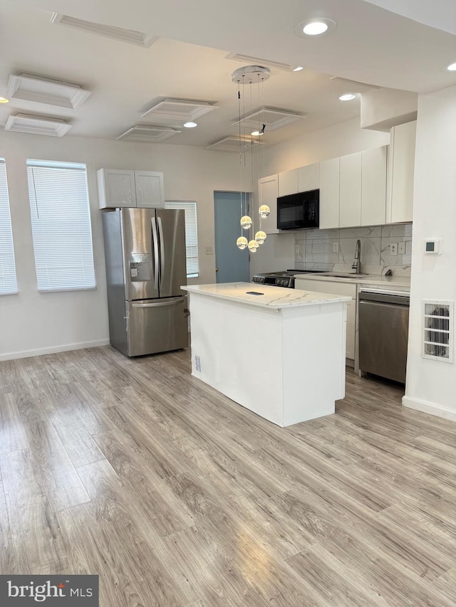 2526 W Franklin St, Baltimore, MD 21223 - kitchen with a center island, tasteful backsplash, black appliances, and light wood-style floors