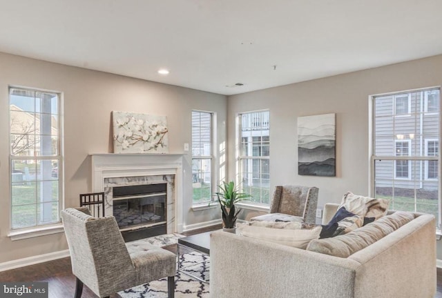 living room featuring recessed lighting, baseboards, a fireplace, and dark wood-style flooring