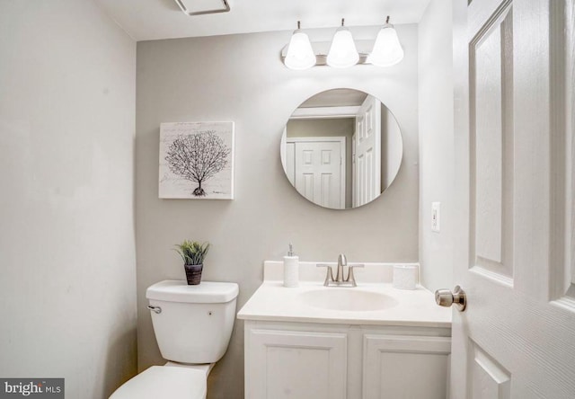 half bathroom featuring vanity and toilet