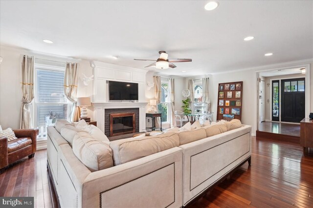 living room with dark wood-style flooring, a ceiling fan, recessed lighting, and a glass covered fireplace