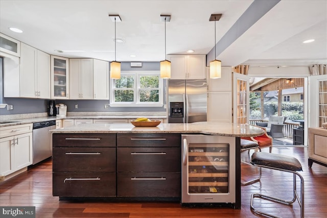 kitchen featuring beverage cooler, white cabinetry, and stainless steel appliances