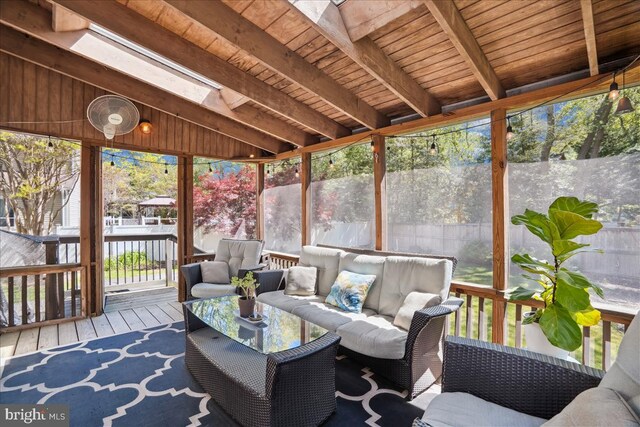 sunroom / solarium with an outdoor living space, beam ceiling, and a wealth of natural light