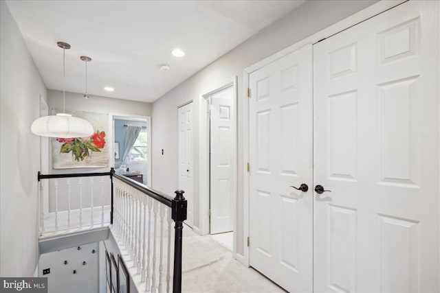 corridor with baseboards, light carpet, recessed lighting, and an upstairs landing