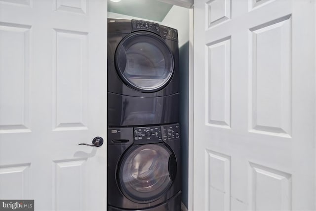 washroom with stacked washing maching and dryer and laundry area