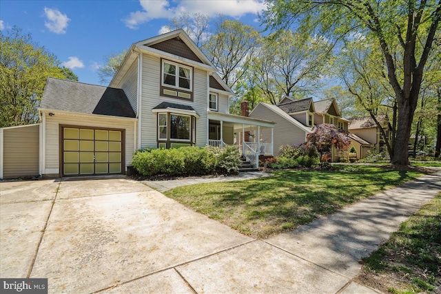 view of front of home with a garage, a front lawn, a porch, and driveway
