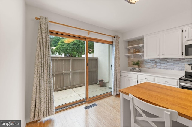 11645 Newbridge Ct, Reston, VA 20191 - kitchen featuring electric range, open shelves, white cabinets, light wood-style flooring, and tasteful backsplash