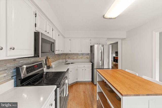 11645 Newbridge Ct, Reston, VA 20191 - kitchen featuring appliances with stainless steel finishes, a sink, white cabinets, and tasteful backsplash