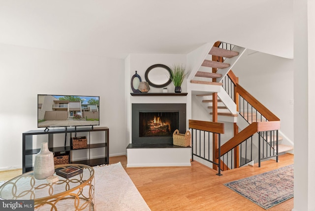 11645 Newbridge Ct, Reston, VA 20191 - living area with wood finished floors, a lit fireplace, stairs, and baseboards